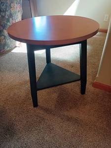 lot 926 image: Small Round Table with Triangle Shaped Bottom Shelf.  28 x 24.  Located in basement