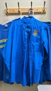 lot 1470 image: Five Blue Rotary Club Shirts Andover Port.  1 long sleeve button down, three polo and one tee.  Sizes L and XL