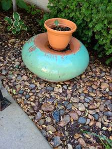 lot 4002 image: Large clay flowerpot currently upside down, 11x24, heavy, plus a hosta start in plastic pot
