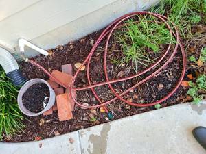 lot 4006 image: Red garden hose and plastic pot, bricks not included