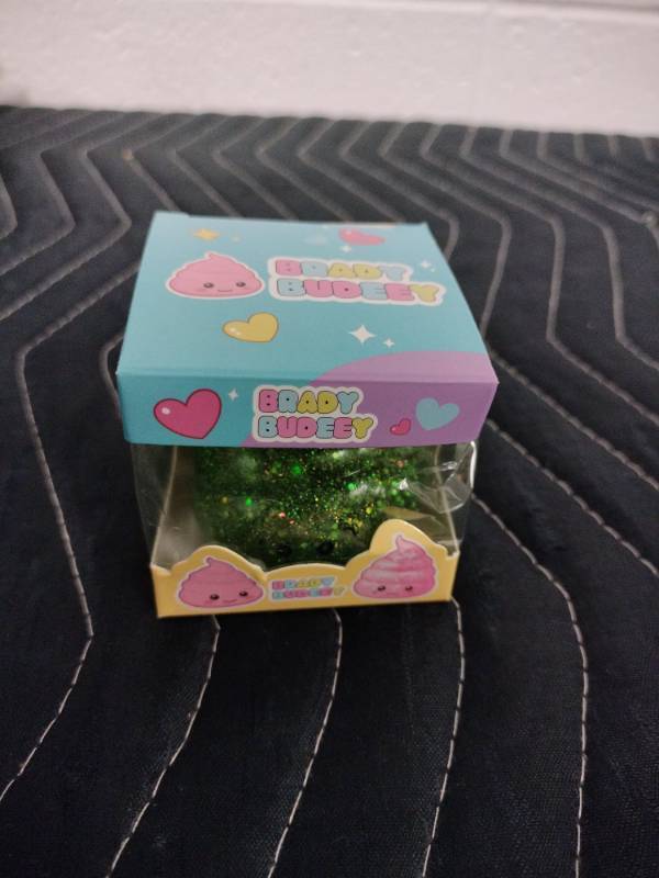 lot 143 image: Brady Budeey Green Glitter Poop Emoji Squishy Toy in Display Box