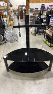lot 500 image: Black glass swivel-mount TV stand with tempered glass shelves and an integrated vertical metal mounting column 53 x 50 x 24 in
