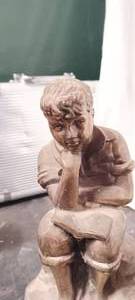 lot 36189 image: A Vintage figurine of a bouy reading a book
