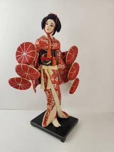 lot 105 image: Vintage Geisha Figure Doll in Red Kimono with Parasol Discs on Black Base
