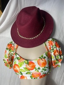 lot 36909 image: Burgundy Wide Brim Felt Fedora Hat With a Gold Tones Chain & Pearl Band.