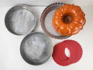 lot 248 image: Bakeware Lot Orange Fluted Bundt Pan, Fluted Tart Pan, 2 Round Pans, 4 Red Rings