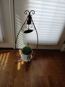 lot 1120 image: Metal Scroll Plant Stand with Pineapple Motif and Oval Plaque with faux plant 31 inches tall