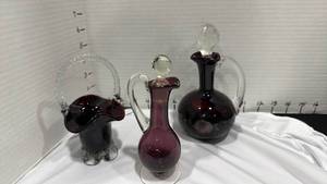 lot 1028 image: Purple amethyst glass cruet, dark cranberry red cruet and basket