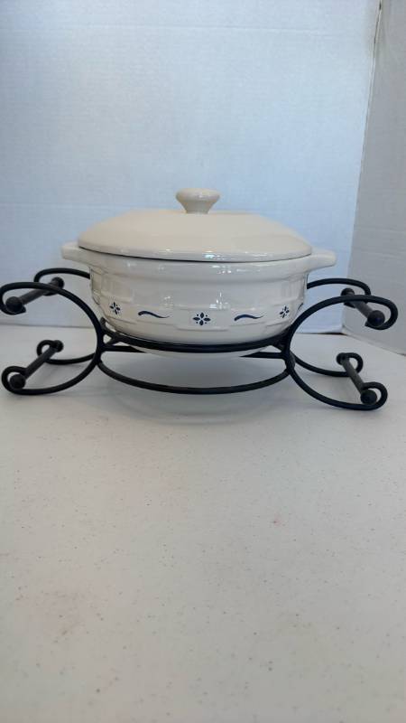 lot 1113 image: Longaberger Woven Traditions Round Covered Casserole Dish resting in a black iron scroll caddy