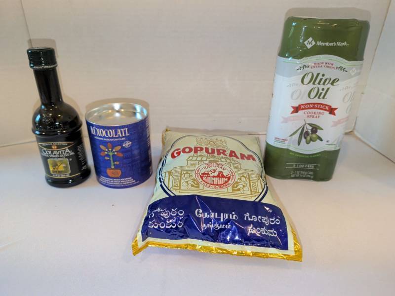lot 1308 image: Lot of 4 Pantry Items Colavita Olive Oil, Ki Xocolati, Gopuram Kumkum, Members Mark olive oil spray