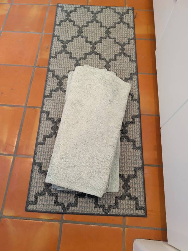 lot 1341 image: Lot of 3 Floor Mats 2 Light Green Textured Bath Mats and 1 Gray Geometric Runner. Runner is 59x24. In laundry room