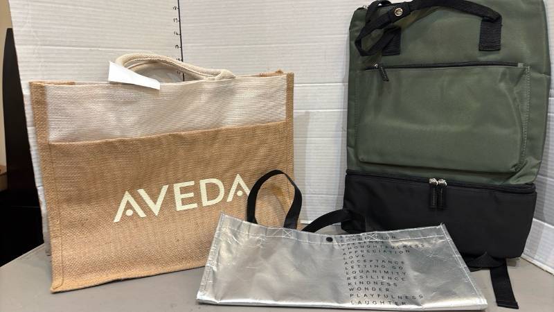 lot 1827 image: Aveda Tote Bag Lot with Green Backpack and Silver Tote Bag