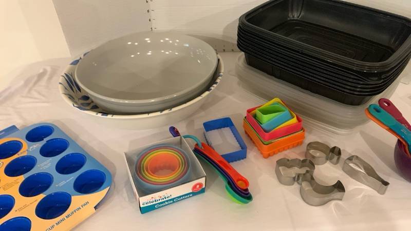 lot 2027 image: Cookie cutters, muffin pan, serving bowls, measuring spoons and cups, and storage container containers