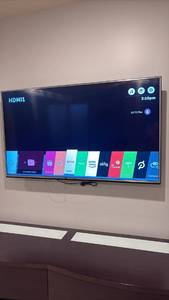 lot 24 image: 60 inch LG TV with remote located in basement