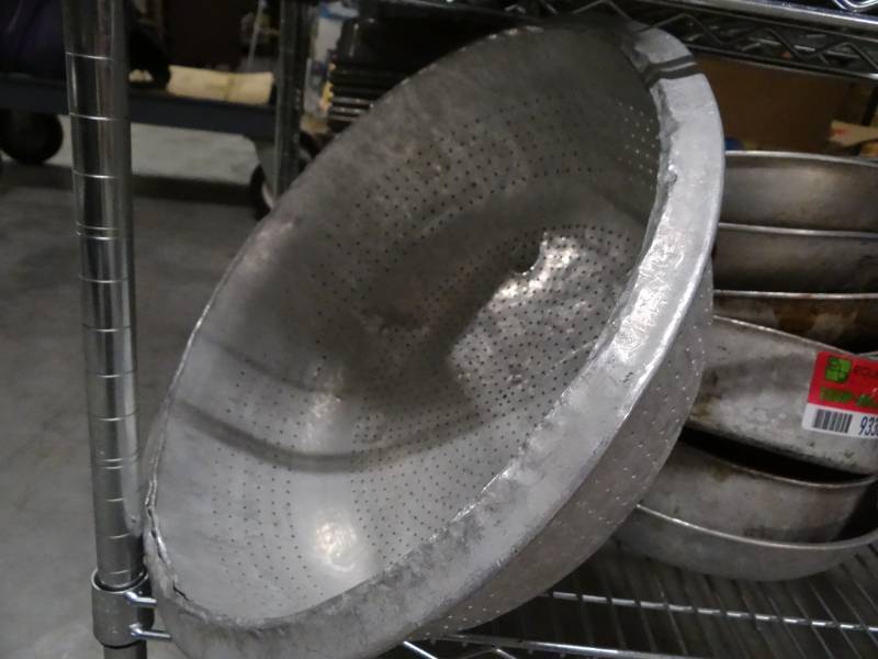 lot 9338 image: Contents of Shelf Large Colander, Stack of Skillets, Metal Cambro Lids, Stack of Cake Pans
