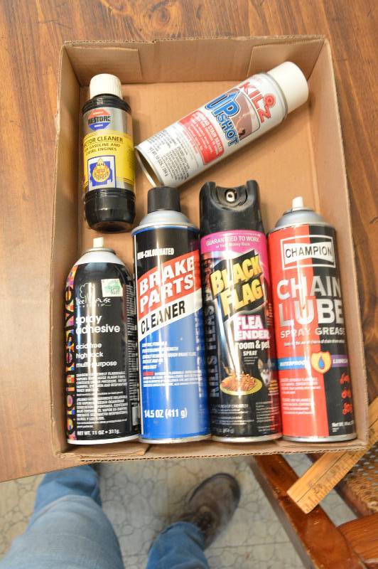 lot 1239 image: Box with Kilz, chain lube, brake cleaner, adhesive, flea ender, and motor cleaner