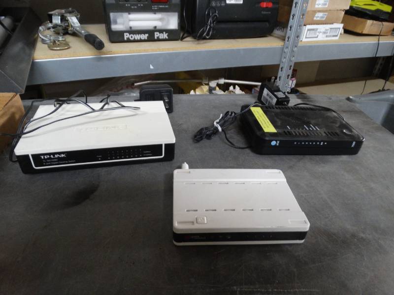 lot 8411 image: Tp-link 8 port gigabit desktop switch, netgear modem and wireless router.