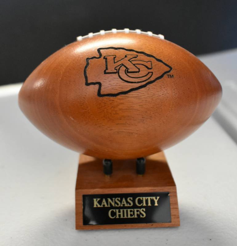 lot 1082 image: Kansas City Chiefs National Football League Wooden Team Logo Football With Stand - 5 Inches Wide - With Metal Team Name Plaque