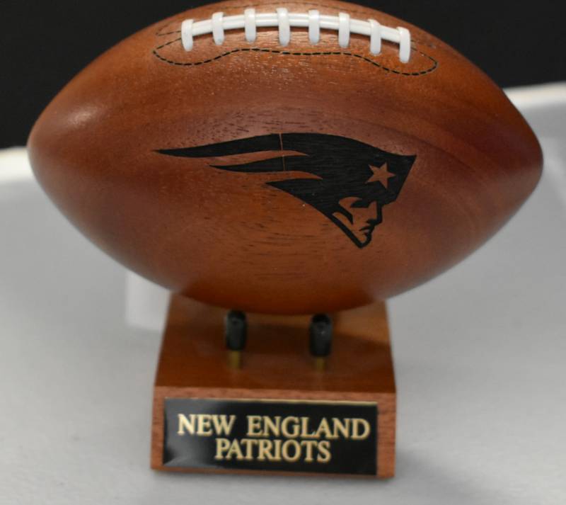 lot 1086 image: New England Patriots National Football League Wooden Team Logo Football With Stand - 5 Inches Wide - With Metal Team Name Plaque