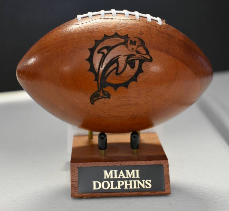 lot 1089 image: Miami Dolphins National Football League Wooden Team Logo Football With Stand - 5 Inches Wide - With Metal Team Name Plaque
