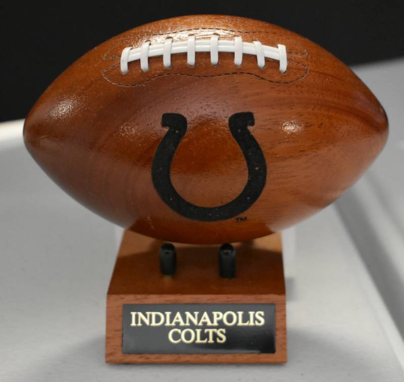 lot 1091 image: Indianapolis Colts National Football League Wooden Team Logo Football With Stand - 5 Inches Wide - With Metal Team Name Plaque