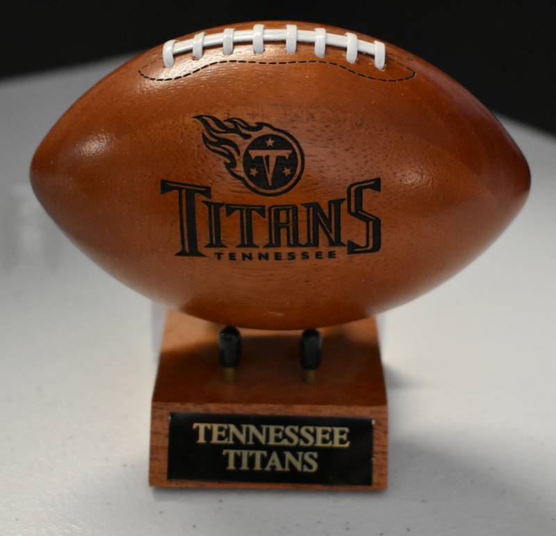 lot 1097 image: Tennessee Titans National Football League Wooden Team Logo Football With Stand - 5 Inches Wide - With Metal Team Name Plaque