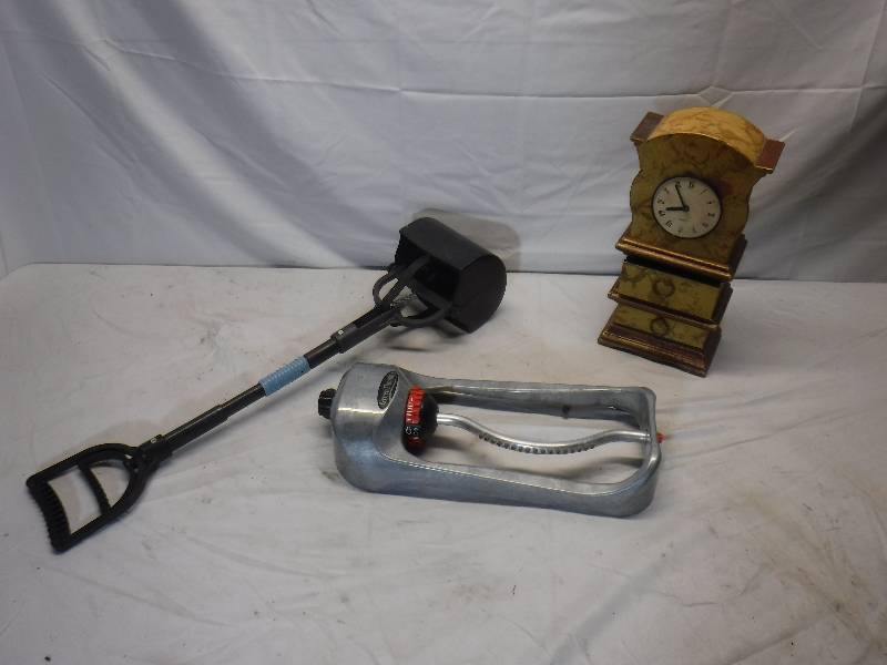lot 12082 image: Desk top clock with drawers, pup poop scooper and sprinkler