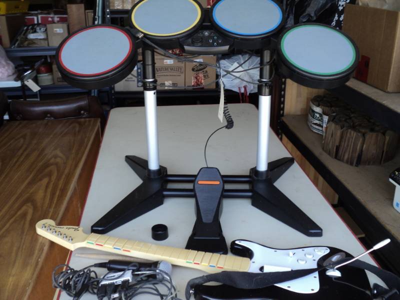 lot 8241 image: Rock Band Set for PlayStation, includes Drums, with foot pedal and drum sticks, Guitar, microphone with power cords, may be incomplete