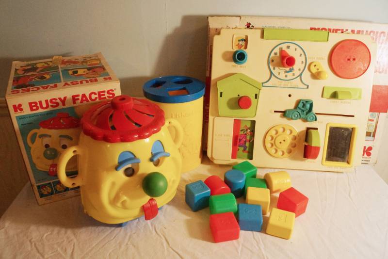 lot 1449 image: Vintage Baby Toys- Busy Faces- Disney Busy Box-Fisher Price Sorting Blocks set- These are hard to find in the original boxes One is dated Christmas 1975 on a handwritten piece of tape.