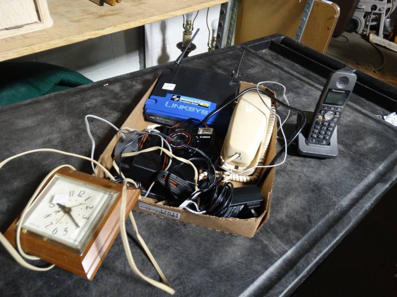 lot 17611 image: Lot of telephones, clock, cords, & router.