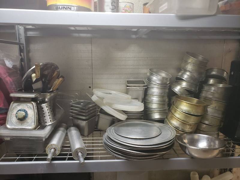 lot 9132 image: Contents on shelf - Insert pans, pizza pans, scale, and utensils