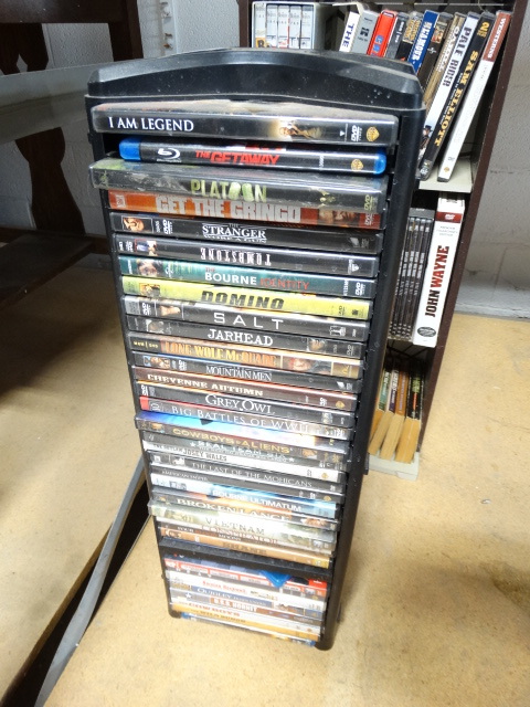 lot 6566 image: Lot of movies on dvd rack.