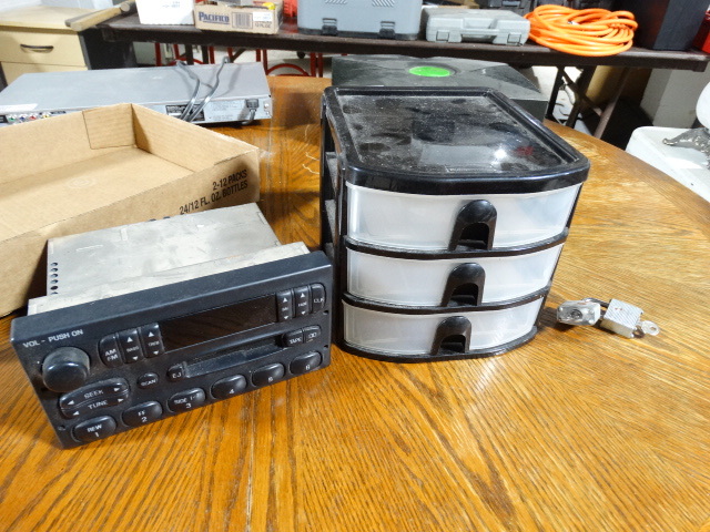 lot 6610 image: Ford stereo and small plastic conatiner.