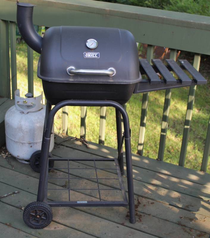 lot 1194 image: Backyard charcoal grill and gas tank