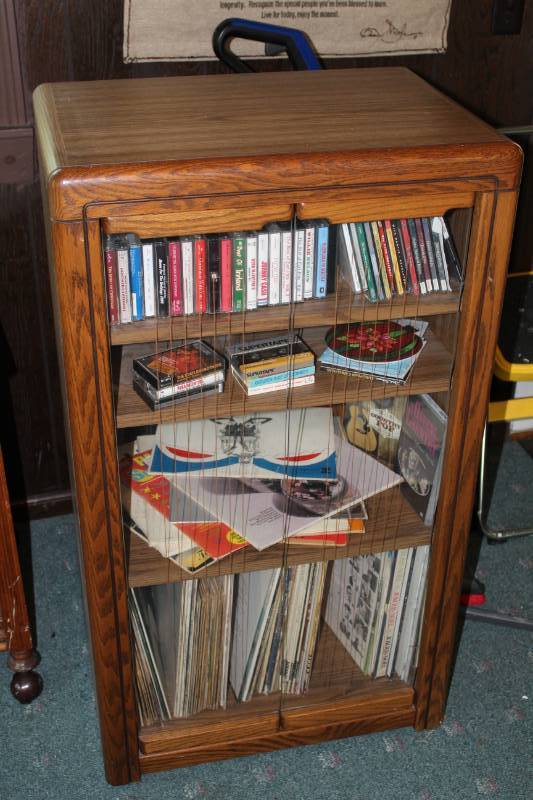 lot 1329 image: Media cabinet full of vintage music record LPs, CDs and cassettes.  Country, Jazz, Soundtracks, Hawaiian music, comedy, amazing collection of music.