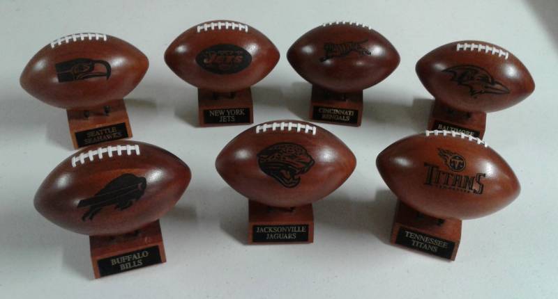 lot 1166 image: Collection of Seven Wooden Mini NFL Football Team Footballs - ALL ONE MONEY