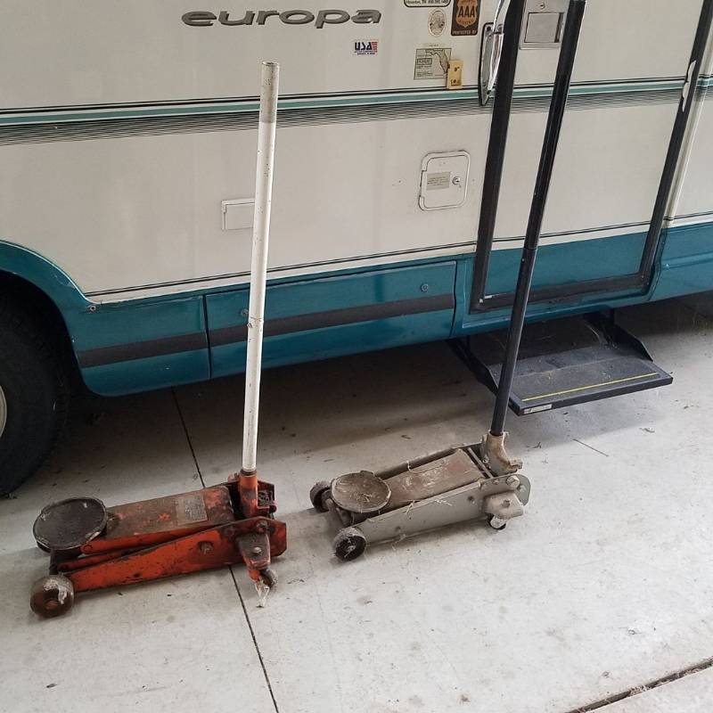 lot 7238 image: two floor jacks - the gray one doesnt pump up, the orange one pumped up but doesnt hold