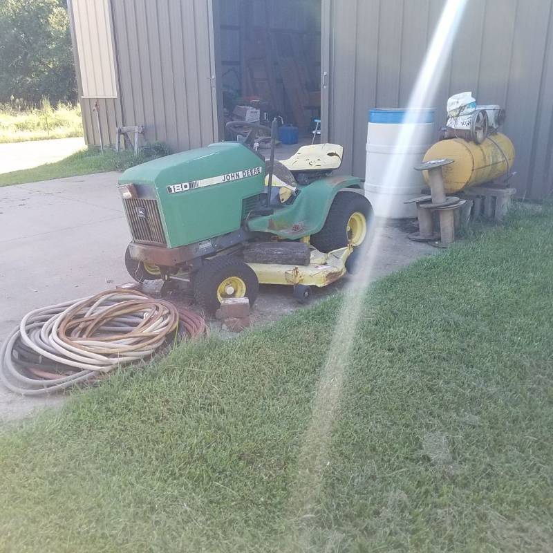 lot 7396 image: John Deere riding lawn mower and air compressor - sitting outside, condition unknown