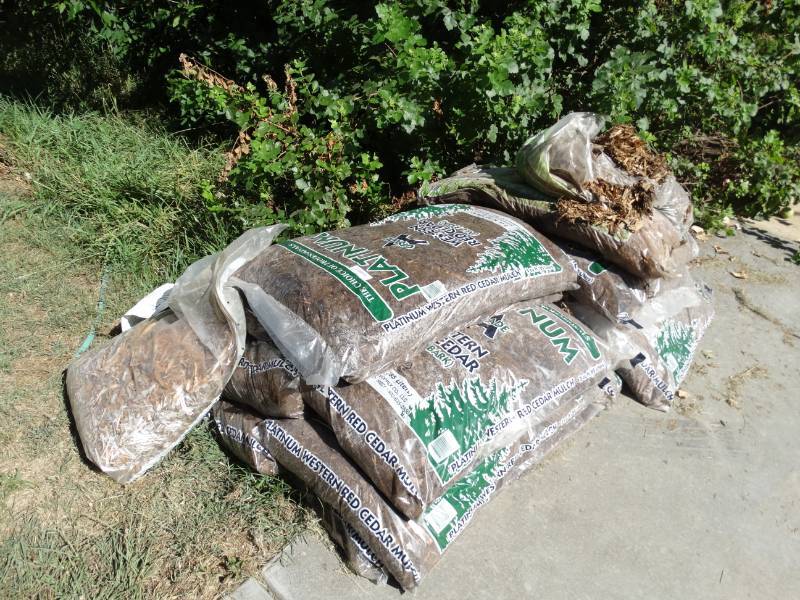 lot 1046 image: Several bags of wood mulch in pile