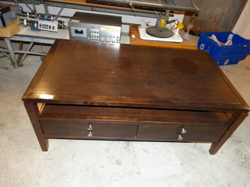 lot 112 image: Wood 2 drawer coffee table. has damage on two corners.