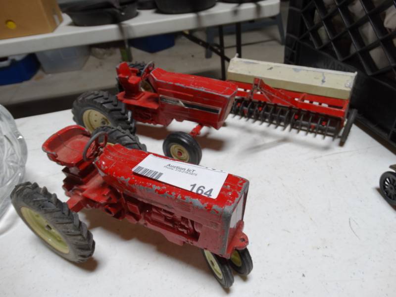 lot 164 image: 2 Die-cast international harvester tractors and farm implement.