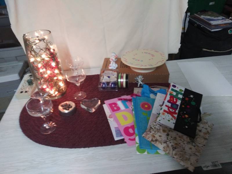 lot 2077 image: Mid Century Modern Orrefors Rhapsody Champagne Glasses, Musical Happy Birthday Plate, Vase with lights and greenery included, gift bags, gift tin with bear on top, ribbon.