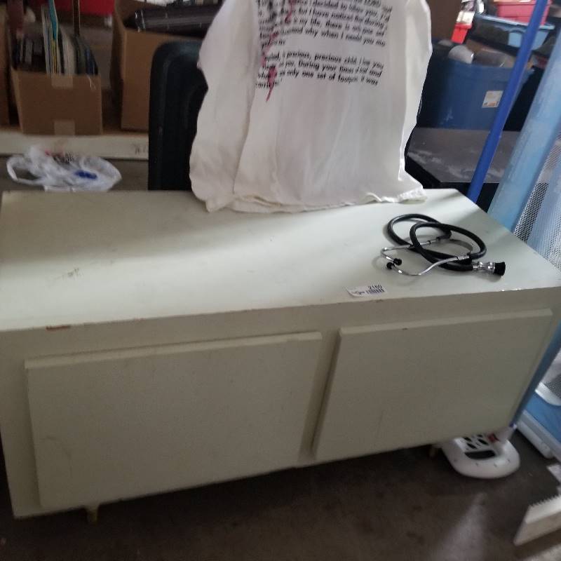 lot 2160 image: Little white two drawer storage cabinet on petite legs, older stethoscope, footprints in the Sand t shirt.