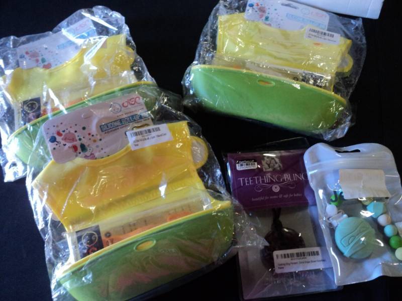 lot 9898 image: Mixed lot Baby accessories, Silicone Roll-up bib, teething bling