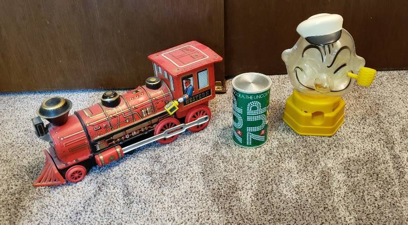 lot 1617 image: Lot of Vintage Tin Litho Western Train Locomotive, 7 up Transistor Radio, and 1968 Hasbro Popeye Plastic Gumball Machine Bank