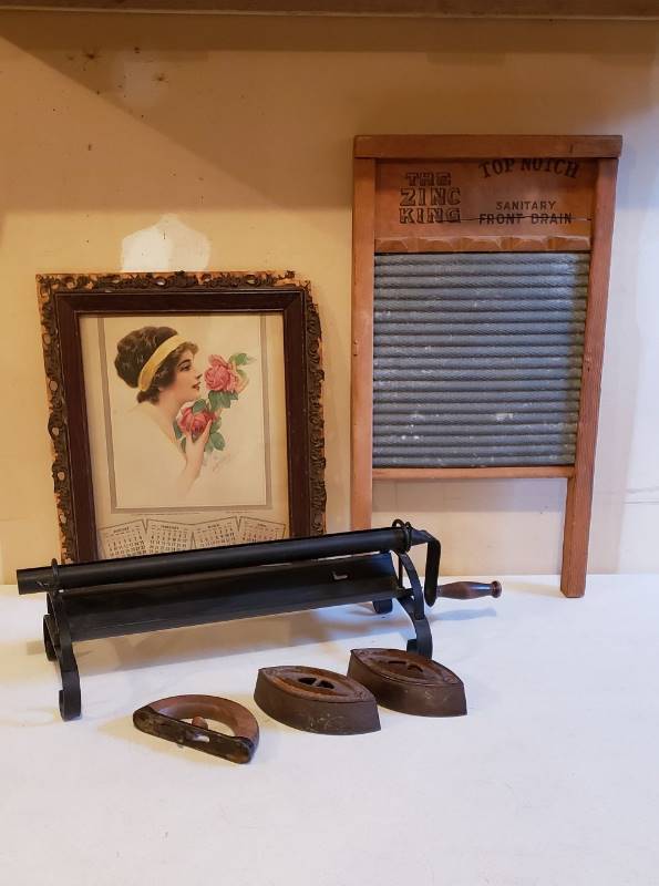 lot 3095 image: Lot of Vintage Household Items - Framed 1916 Calendar, Washboard, Newspaper Roller, and 2 Sad Irons with one handle