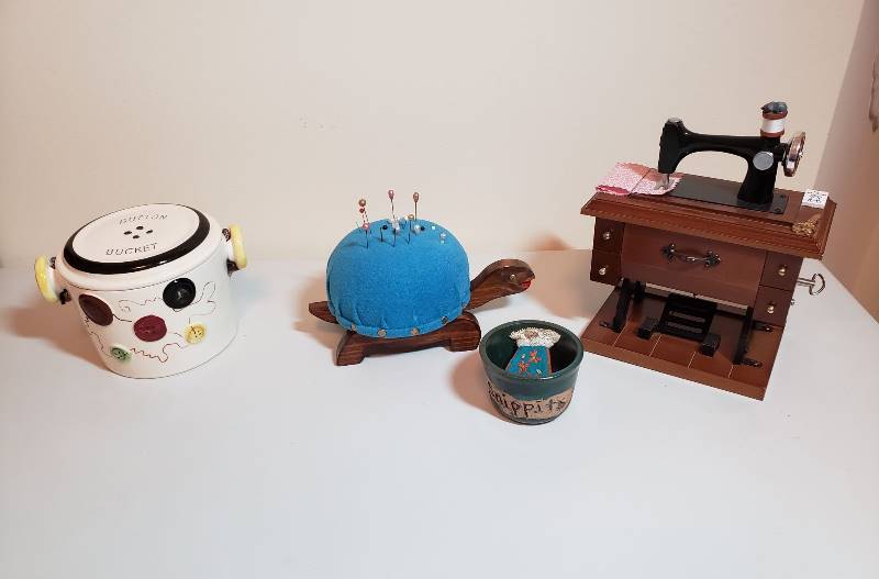 lot 3162 image: Vintage Fred Roberts Company Button Bucket, Turtle Pin Cushion, Snippets Bowl and Vintage Berkeley Design  Button and Bows  Sewing Machine Music Box