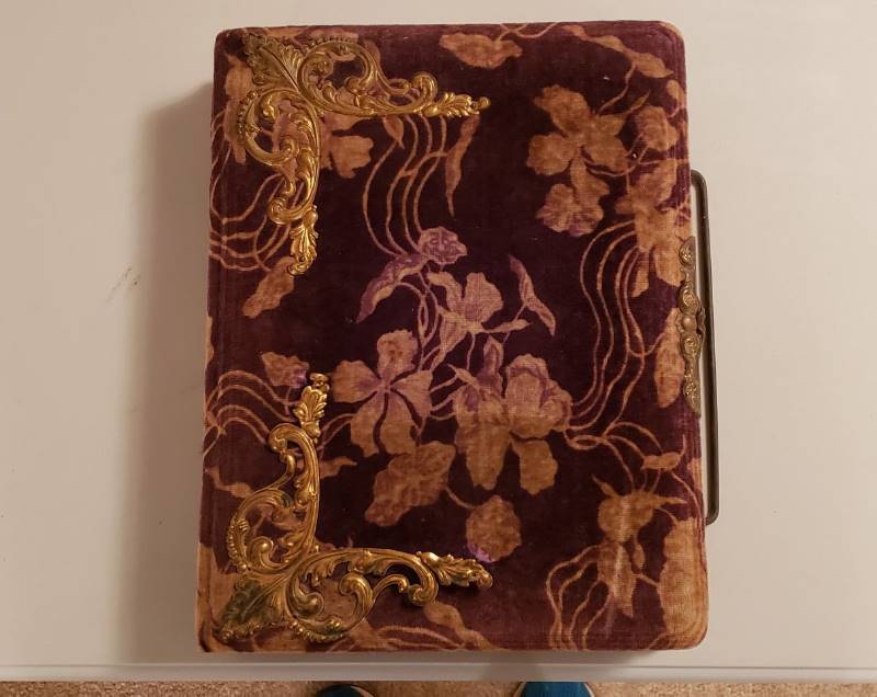 lot 3273 image: Antique Late 1800s Velvet Victorian Photo Album with 26 photos (3 are Tin Type Photos) - Latch works and Wire Handle Attached Well - one of the Brass Adorements needs tacked on