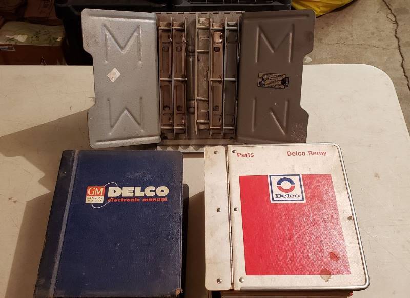 lot 2344 image: Vintage Automotive GM Delco Electronic Manual, Delco Parts Catalog, and Metal Catalog Holder