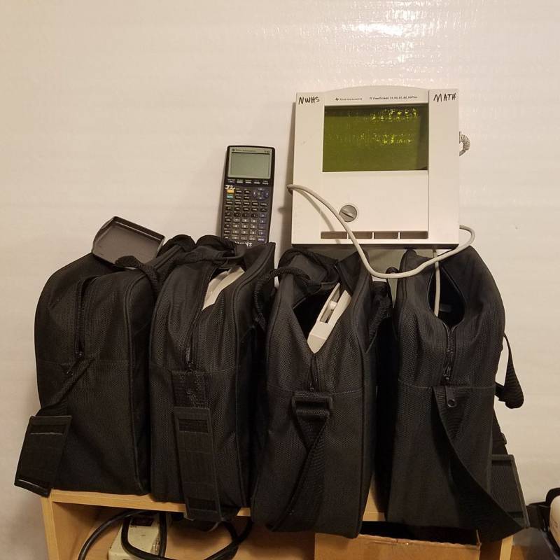 lot 3305 image: Lot of 4 graphing calculator projectors, 1 includes TI-83 graphing calculator. Projectors can handle TI-73, TI-80, TI-81, TI-82, TI-83, TI-83 Plus, and TI-84 Plus